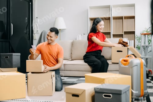 Preview: Happy asian young attractive couple man and woman with big boxes moving into a new house