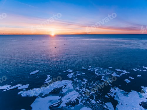 Preview: Aerial drone view of a blue sea water with ice and sunset sky. Beautiful winter landscape in Finland