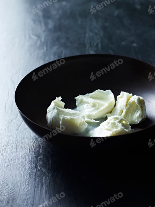 Preview: Fresh mozzarella cheese on a dark plate.