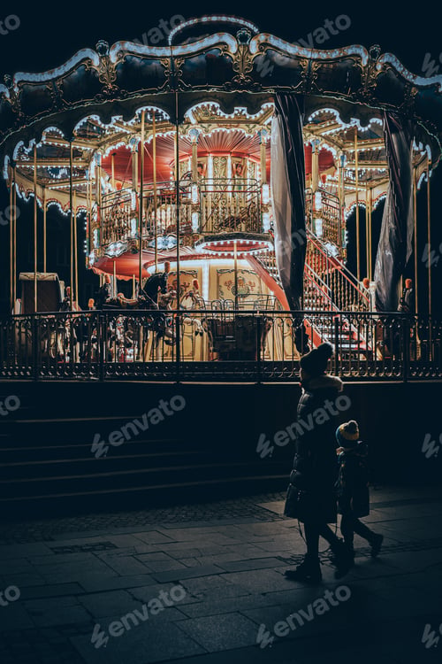 Preview: mom with a baby is standing by the carousel
