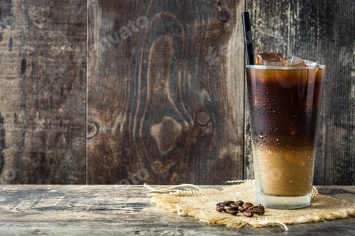 Preview: Iced coffee sitting on rustic wooden table with coffee beans