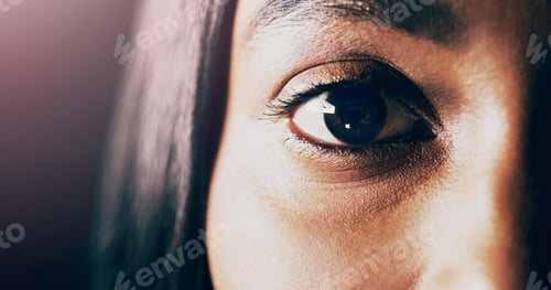 Preview: Hidden in plain sight. Closeup shot of a beautiful young womans eye against a dark background.