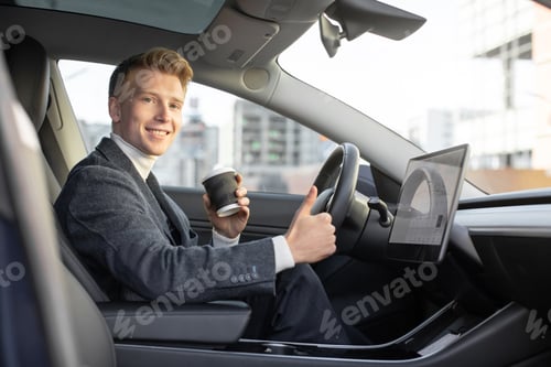Preview: Handsome smiling Caucasian business man riding autonomous car, drinking coffee to go