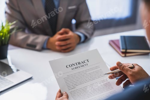 Preview: An employer interviewing for a job or head of HR is reading a resume while discussing the job applic