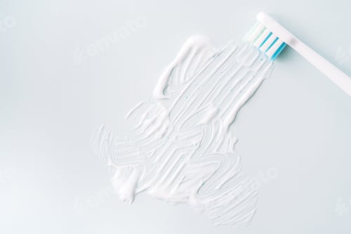 Preview: Smeared toothpaste with electric toothbrush over blue background