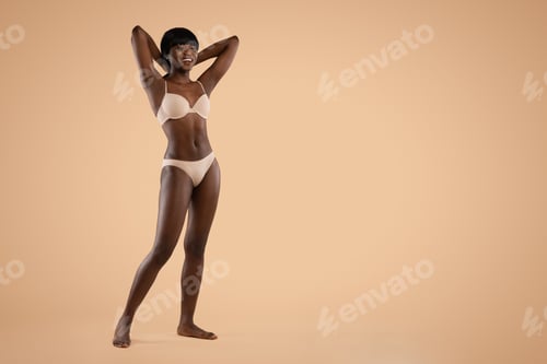 Preview: Happy attractive black lady posing in underwear on beige