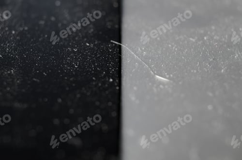 Preview: Close-up of dust and dirt on a black and gray surface. Macro photography, selective focus