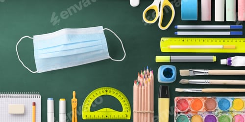 Preview: Flat lay top view of face mask and school supplies, back to school and coronavirus concept