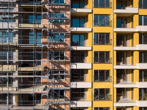 Preview: Drone flight along the facade of a modern apartment building under construction surrounded by