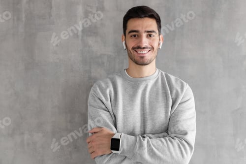 Preview: Portrait of smiling handsome man wearing smart watches, standing with crossed arms