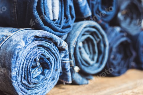 Preview: Jeans stacked on a wooden background
