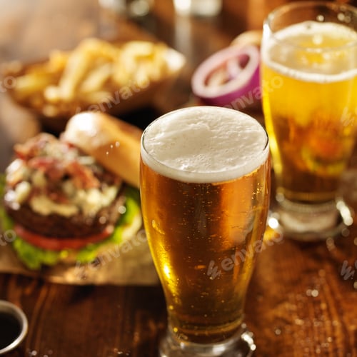 Preview: cold beer with foamy head and burgers