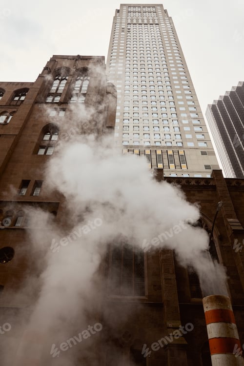 Preview: low angle view of red brick catholic church and skyscraper near steam on street in new york city