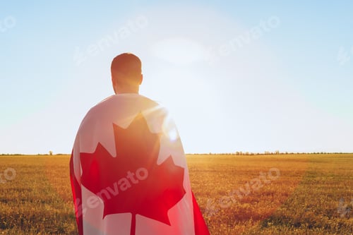 Preview: Man with a flag of Canada standing in field