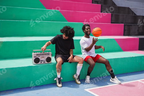 Preview: Diverse african men sitting in the city while listening music from vintage boombox stereo