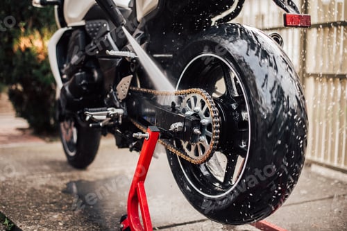 Preview: Cleaning motorcycle chain, rear view, close-up.