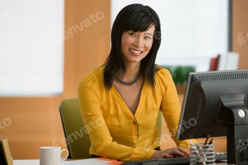 Preview: Young woman working at desk