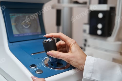 Preview: Doctor using joystick of automated refractor during eye diagnostics