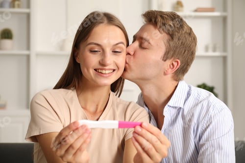 Preview: Happy couple with pregnancy test at home