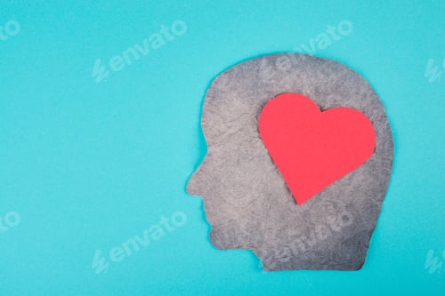 Preview: Silhouette of a face with a red colored heart, paper, blue background, copy space, emotion symbol