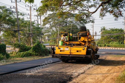 Preview: Yellow steamroller or soil compactor working on asphalt road at construction site
