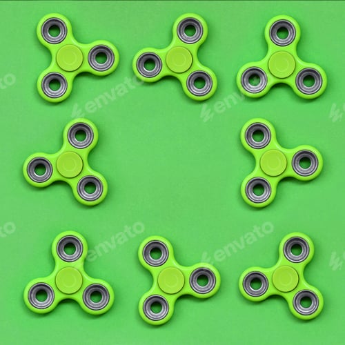 Preview: Many green fidget spinners lies on texture background of fashion pastel green color paper