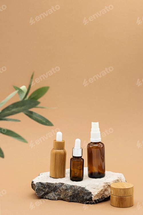 Preview: Glass and Bamboo Essential Oil Bottles with Pipette, Spray Bottle and BambooJar on Stone Podium.