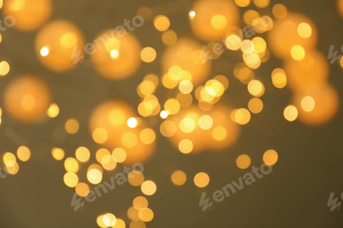 Preview: Blurred view of gold lights on dark background. Bokeh effect