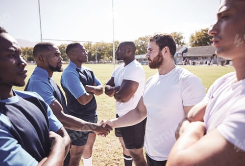 Preview: Two opponent rugby teams shaking hands before or after a match outside on a field. Rugby players sh