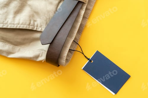 Preview: new brown casual trousers pants with copy space on a sale price tag isolated on colorful background