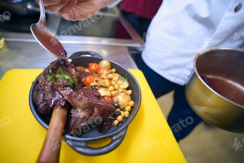 Preview: Cook prepares meat with vegetables and sauce for serving