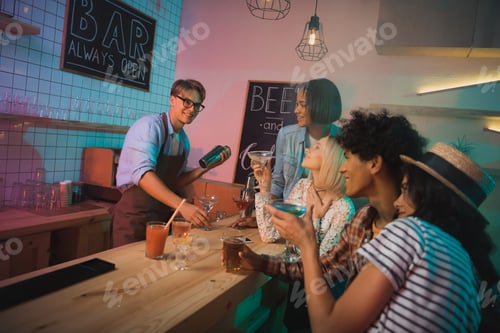 Preview: young barmen making alcohol cocktail for friends in bar