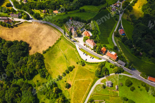 Preview: Aerial view of green hills and vineyards with mountains in background