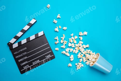 Preview: Clapperboard and pop corn on blue color background, top view