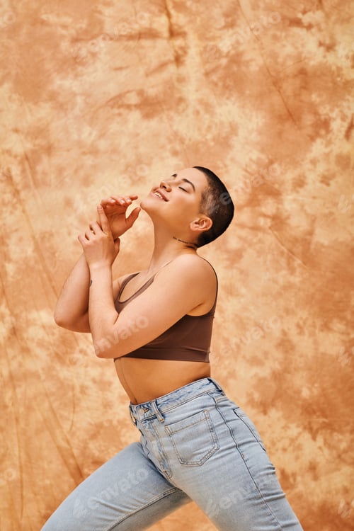 Preview: denim fashion, gen z, happy curvy woman with tattoo posing on mottled beige background, body