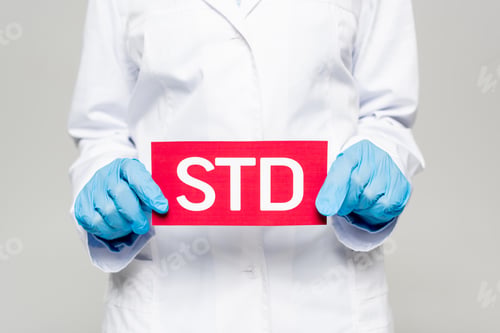 Preview: cropped view of doctor in blue latex gloves and white coat holding std lettering isolated on grey