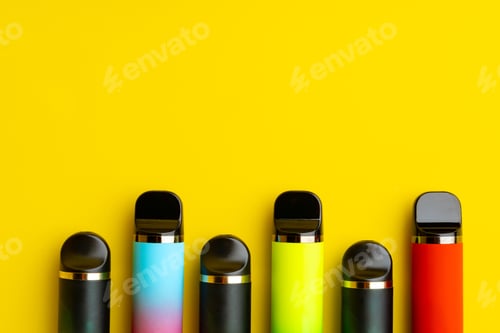 Preview: Colorful disposable electronic cigarettes on yellow background