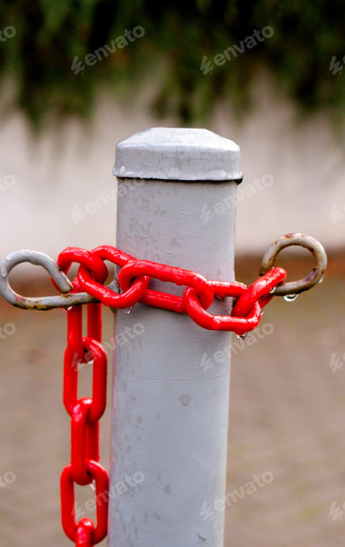 Preview: Vertical shot of a red chain around an iron column
