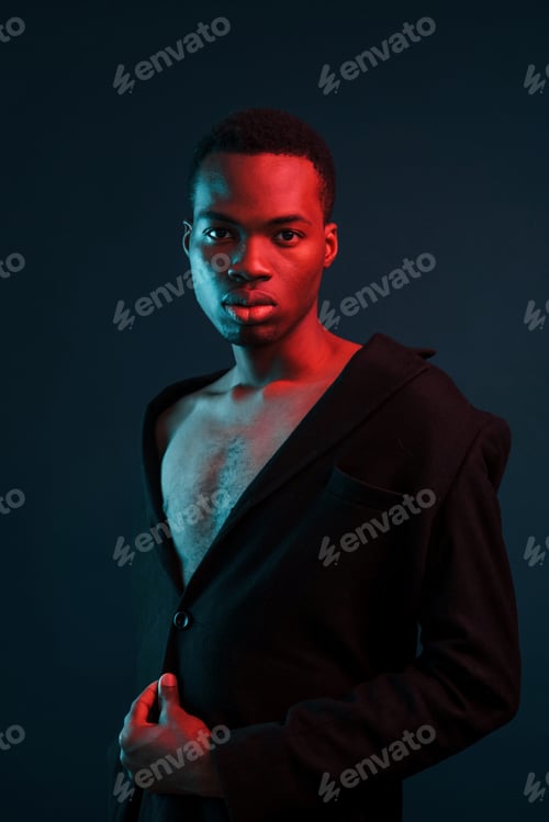 Preview: Confident and serious. Futuristic neon lighting. Young african american man in the studio
