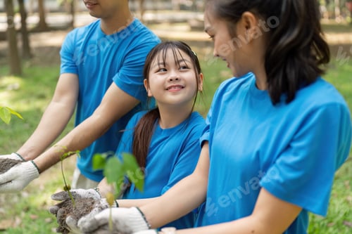 Preview: Family volunteers planting trees together to support environmental conservation and save the world