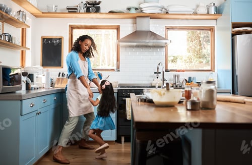 Preview: Shot of a young woman dancing with her daughter in the kitchen at home