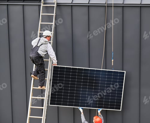 Preview: Workers lifting up photovoltaic solar module while installing solar panel system on roof of house.