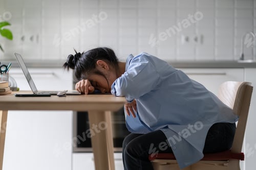 Preview: Tired exhausted Asian girl freelancer sleeping while working from home, lying on desk with laptop