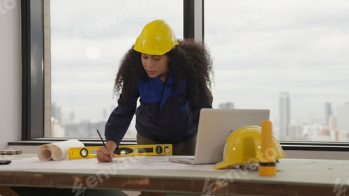 Preview: Female Engineer Reviews Plans in Urban Office
