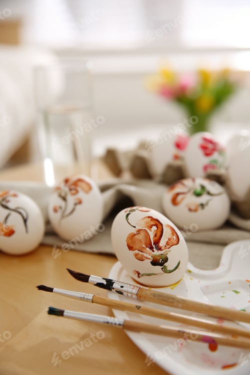 Preview: Beautifully painted Easter eggs and brushes on wooden table