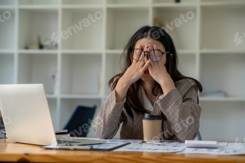 Preview: tired business woman sleepy and bored from sitting at a desk for a long time and has office syndrome