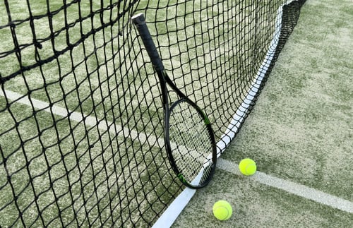 Preview: Close up of tennis balls on court by net