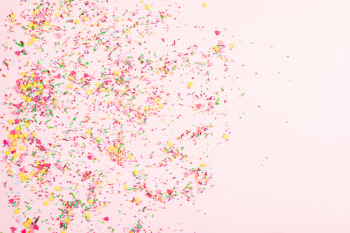 Preview: Colorful sprinkles on pink background, top view. Confectionery decor