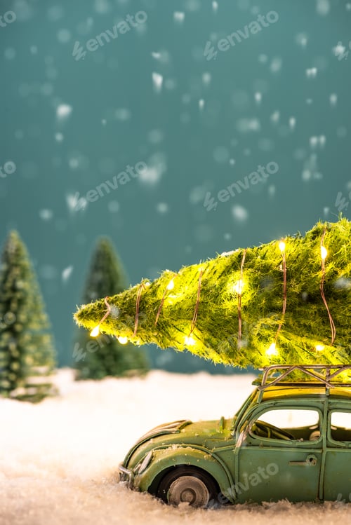 Preview: Festive Greeting Card. Toy Car Carry Illuminated Christmas Tree on Roof in Snow