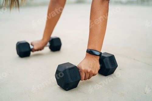 Preview: Woman doing push-ups with dumbbells and smart watch